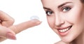 Contact lens on index finger near beautiful female face. Royalty Free Stock Photo