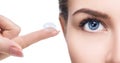 Contact lens on index finger near beautiful female face. Royalty Free Stock Photo