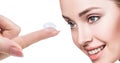 Contact lens on index finger near beautiful female face. Royalty Free Stock Photo