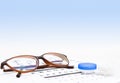 Contact lenses case and eye glasses on and eye test chart. Vision concept. Way to improve vision Royalty Free Stock Photo