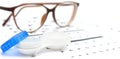 Contact lenses case and eye glasses on and eye test chart. Vision concept. Way to improve vision Royalty Free Stock Photo
