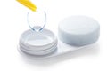 Contact lenses in containers and yellow tweezers