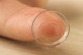 Contact lenses for eyes on a human finger on a wooden table