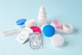 Contact lenses and cases with eye drops bottle on blue background