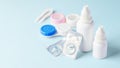 Contact lenses, solution bottle and eye drops with accessories on blue background Royalty Free Stock Photo
