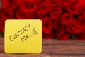 Contact me text with Red roses in a bunch as a background. Royalty Free Stock Photo