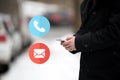 Contact Us. Businessman holding a smartphone mobile, stuck in traffic on a snow cold winter day. Man in coat, cars Royalty Free Stock Photo