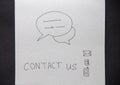 Contact us handwritten lettering on white paper on dark