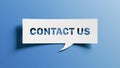 Contact us message cutout in white paper speech bubble on blue background for communication and customer support concepts Royalty Free Stock Photo