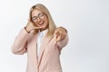 Contact us. Smiling business woman pointing finger at camera and showing phone call gesture, promoting her company Royalty Free Stock Photo