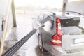 Contactless  car wash self service system. Washing dirty car in car wash station with foam Royalty Free Stock Photo