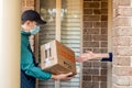 Contactless delivery during COVID-19 pandemic lockdown concept. Courier wearing mask and gloves deliver a parcel with medical