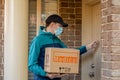 Contactless delivery during COVID-19 pandemic lockdown concept. Courier wearing mask and gloves holds a parcel