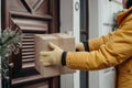 Contactless delivery service concept. hands with package by the doorstep, safe courier drop-off Royalty Free Stock Photo