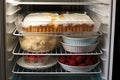 Container with berry pie in the refrigerator. Frozen semi-finished baked goods with juicy berries and cream for long