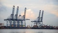 Container Cargo freight ship with working crane bridge in shipyard at dusk for Logistic Import Export Royalty Free Stock Photo