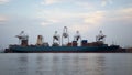 Container Cargo freight ship with working crane bridge in shipyard at dusk for Logistic Import Export Royalty Free Stock Photo