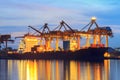 Container Cargo freight ship with working crane loading bridge in shipyard at dusk for Logistic Import Export background Royalty Free Stock Photo