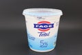 Container of FAGE Greek Yogurt isolated against dark background.