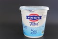 Container of FAGE Greek Yogurt isolated against dark background.