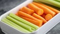 A container filled with fresh celery sticks and sliced carrots, ideal for healthy snacking Royalty Free Stock Photo