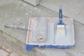 Container with paint roller and brush Royalty Free Stock Photo