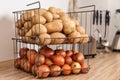 Container with potatoes and onions on kitchen counter. Orderly storage