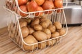 Container with potatoes and onions on kitchen counter. Orderly storage Royalty Free Stock Photo