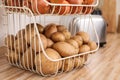 Container with potatoes and onions on kitchen counter. Orderly storage Royalty Free Stock Photo