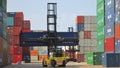 Container reach stacker moving shipping containers around the storage yard at Southampton docks UK