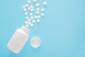 Container and scattered pills isolated on blue background. Pills Spilling Out Of Pill Bottle. Top View With Copy Space Royalty Free Stock Photo