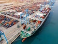 Container ship being loaded and unloaded at terminal freight port, international shipping and global commerce, modern cargo harbor Royalty Free Stock Photo