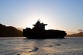 Container ship leaving the port of Santos, Brazil, during a summer sunset Royalty Free Stock Photo