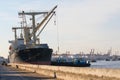 Container ship loading material goods from local ship in habor p