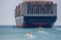 Container ship near the coast with tugboat and small vessels Royalty Free Stock Photo