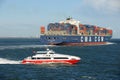 Container ship and a passenger catamaran passing the stern UK