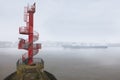 A red tower with a spiral staircase in Finkenwerder. A container ship on the river.