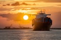 Container ship sails at sunset, representing international freight shipping Royalty Free Stock Photo