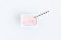 Container with strawberry yogurt and spoon, top view, isolated o Royalty Free Stock Photo