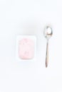 Container with strawberry yogurt and spoon, top view, isolated o Royalty Free Stock Photo