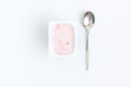 Container with strawberry yogurt and spoon, top view, isolated o Royalty Free Stock Photo