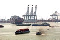 Container terminal and container ship on the Mekong river, Saigon port, Vietnam. View of the piers and cranes at sunrise.