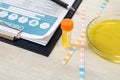 Container with urine sample for analysis, litmus paper and medical report on table Royalty Free Stock Photo