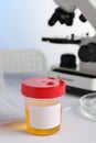 Container with urine sample for analysis on white table in laboratory Royalty Free Stock Photo