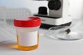 Container with urine sample on white table in laboratory, space for text. Specimen collection Royalty Free Stock Photo