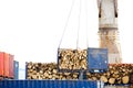 Container witg wood being lifted by a crane