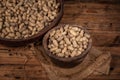 The container on the wood grain table is full of peanuts Royalty Free Stock Photo