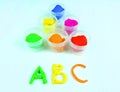 Containers with colorful plasticine and the child made numbers one , two, three. white wooden background