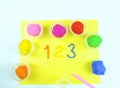 Containers with colorful plasticine and the child made numbers one , two, three.  white  wooden background Royalty Free Stock Photo