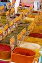 Containers with colorful spices and herbs in the market. Spice name plates